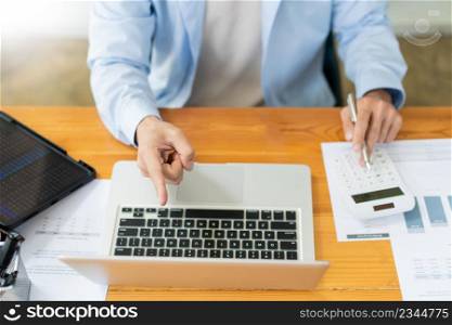 Business analyst concept the accountant using a calculator to estimate the amount of profits.