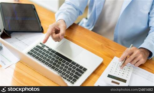 Business analyst concept the accountant using a calculator to estimate the amount of profits.