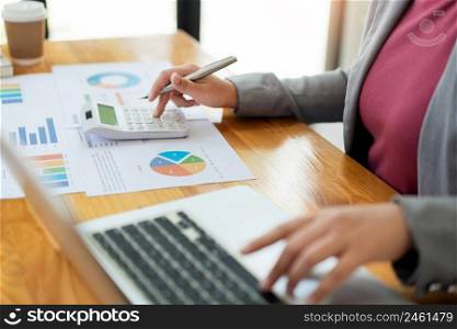 Business analyst concept the accountant using calculator to check the correctness of the data in the laptop.