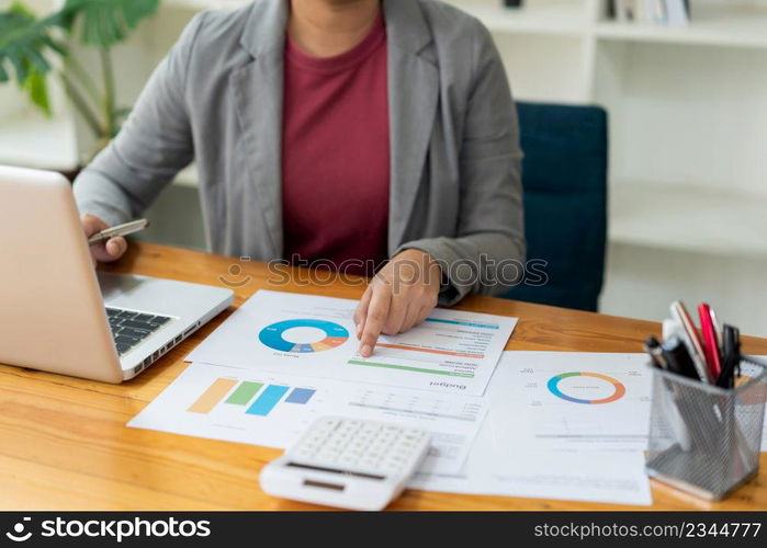 Business analyst concept the data analyst holding and pointing her pen at the document about sale chart.