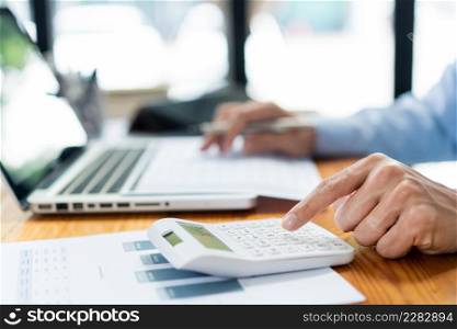 Business analyst concept the male accountant concentrating on sale detail while pressing his calculator.