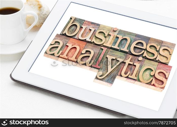business analytics typography - text in letterpress wood type blocks on a digital tablet with a cup of coffee