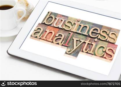 business analytics typography - text in letterpress wood type blocks on a digital tablet with a cup of coffee