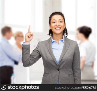 business and advertisement concept - attractive young woman with her finger up at office