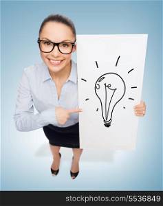 business and advertisement concept - smiling businesswoman in eyeglasses pointing finger to white board with light bulb
