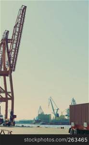 Business and commerce. Cranes at port area, cargo container yard. Industrial scene