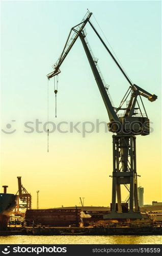 Business and commerce. Heavy load dockside cranes in port, cargo container yard. Industrial scene