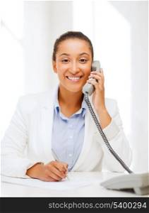 business, and communication concept - smiling african businesswoman with phone in office
