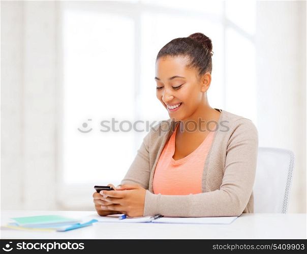 business, and communication concept - smiling african woman with smartphone in office