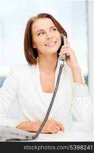 business and communication concept - smiling businesswoman with phone in office