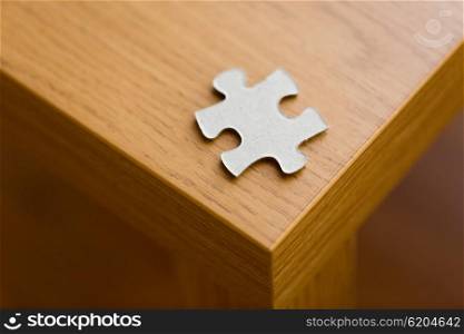 business and connection concept - close up of puzzle piece on wooden surface. close up of puzzle piece on wooden surface