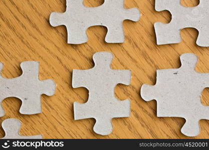 business and connection concept - close up of puzzle pieces on wooden surface. close up of puzzle pieces on wooden surface