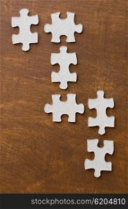business and connection concept - close up of puzzle pieces on wooden surface. close up of puzzle pieces on wooden surface
