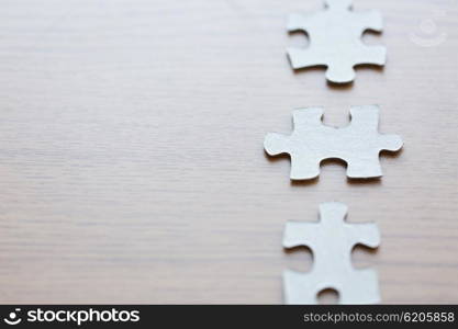business and connection concept - close up of puzzle pieces on wooden surface. close up of puzzle pieces on wooden surface