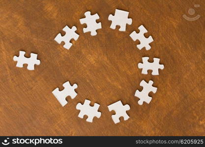 business and connection concept - close up of puzzle pieces on wooden surface. close up of puzzle pieces on wooden surface