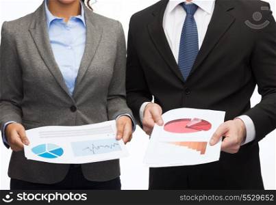 business and economy concept - smiling businesswoman and businessman with graphs and charts