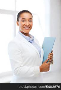 business and education concept - african businesswoman with folder in office