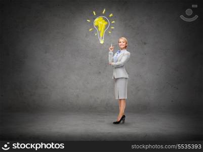 business and education concept - attractive young businesswoman with her finger up and light bulb