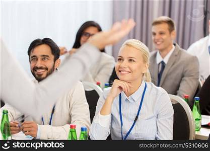 business and education concept - businesswoman or lecturer talking to group of people at conference or lecture. group of people at business conference or lecture