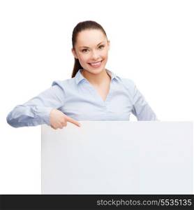 business and education concept - friendly young smiling businesswoman pointing finger to white blank board