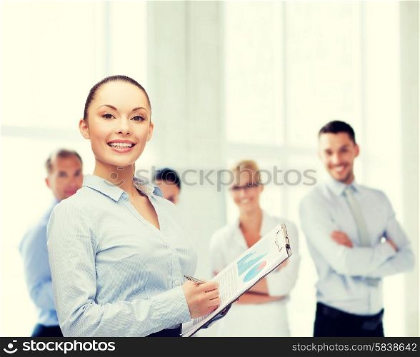 business and education concept - friendly young smiling businesswoman with clipboard and pen