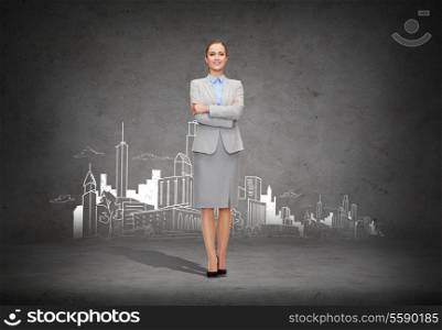 business and education concept - friendly young smiling businesswoman with crossed arms with city on the back
