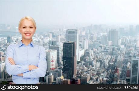 business and education concept - friendly young smiling businesswoman with crossed arms