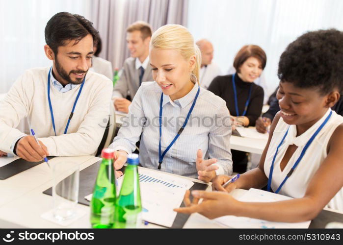 business and education concept - group of people at international conference discussing papers. happy business team at international conference