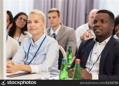 business and education concept - group of people at international conference or lecture. happy business team at international conference