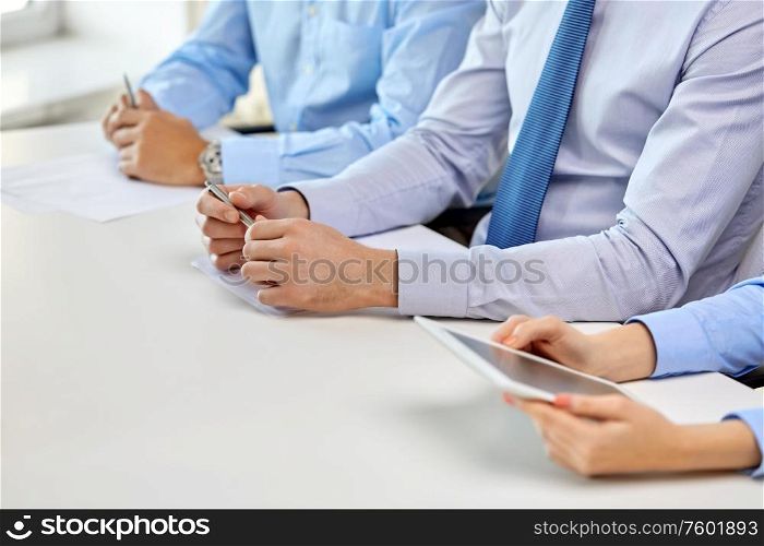 business and education concept - hands of people with pens and papers at conference at office. hands of business people at conference at office