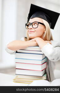 business and education concept - happy student in graduation cap with stack of books