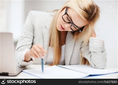 business and education concept - indoor picture of bored and tired woman taking notes