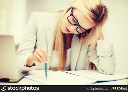 business and education concept - indoor picture of bored and tired woman taking notes