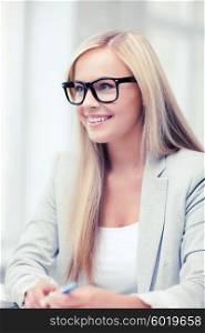 business and education concept - indoor picture of smiling woman with eyeglasses. businesswoman with glasses