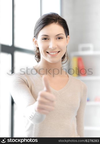 business and education concept - lovely teenage girl showing thumbs up gesture