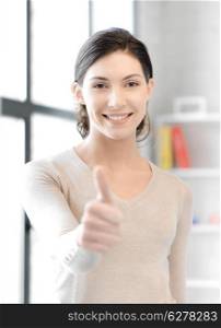 business and education concept - lovely teenage girl showing thumbs up gesture