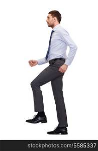 business and education concept - serious businessman stepping on imaginary step