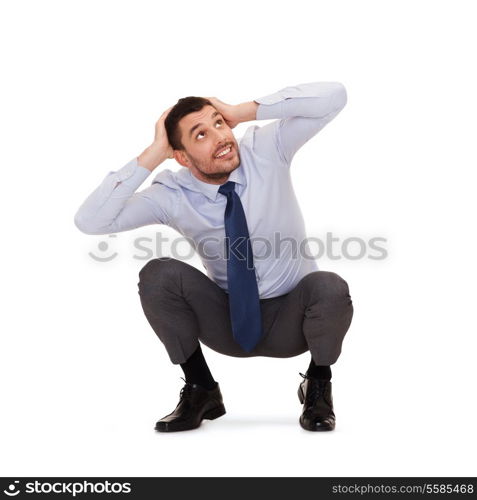 business and education concept - smiling businessman crouching on the floor