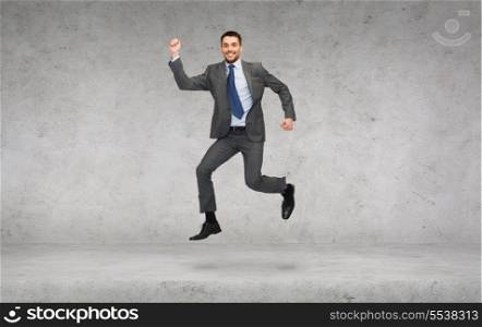 business and education concept - smiling businessman jumping