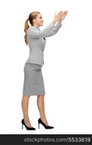 business and education concept - smiling businesswoman holding something imaginary