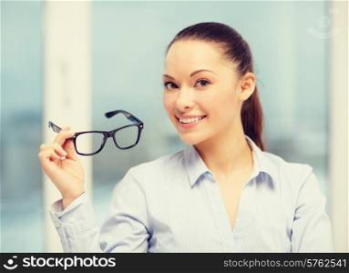 business and education concept - smiling businesswoman with eyeglasses
