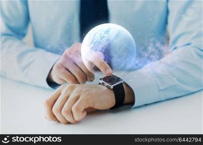 business and future technology concept - close up of hand with virtual hologram of planet over smart watch. hands with planet hologram over smart watch