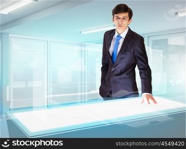 Business and high-tech innovations. Image of young businessman looking at high-tech picture
