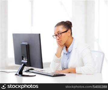 business and internet concept - african businesswoman with computer in office