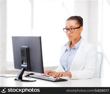 business and internet concept - african businesswoman with computer in office