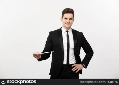 Business and Job Concept: Elegant man in the suit holding resume for job hiring in the bright white interior. Business and Job Concept: Elegant man in the suit holding resume for job hiring in the bright white interior.