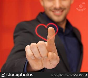 business and love concept - handsome man in suit pressing heart-shaped virtual button