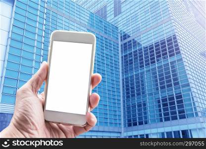 Business and modern technology concept. Closeup hand holding mobile with blank screen with blue glasses window in city background. Wireless network connection concept.
