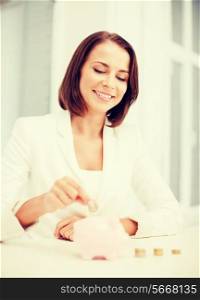 business and money saving concept - woman putting coin into piggy bank