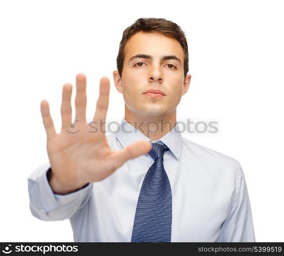 business and office, ban, veto, warning concept - attractive buisnessman making stop gesture